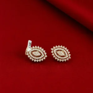 Gold-tone floral stud earrings with sparkling clear stones displayed on a luxurious red background.