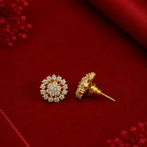 Elegant gold-tone floral crystal stud earrings displayed on a rich red satin background with delicate decorative accents