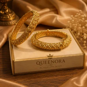 "Queenora gold-tone designer bangles with intricate geometric detailing displayed on a luxury jewellery box"